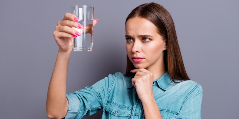 woman concerned about the water in glass