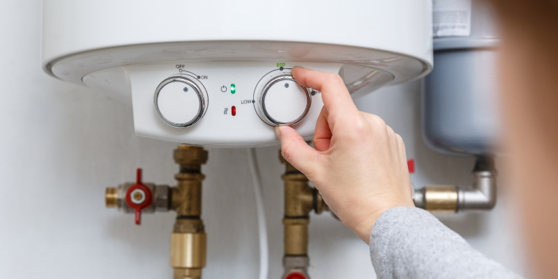 Homeowner changing settings on water heater - Why The Big Water Heater Rental Companies Aren’t Telling You the Truth
